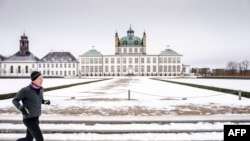 Čovjek trči pored snijegom prekrivene rezidencije danske kraljice Margrete u Fredensborgu, 9. januara 2024. (Foto: AFP/Mads Claus Rasmussen/Ritzau Scanpix)