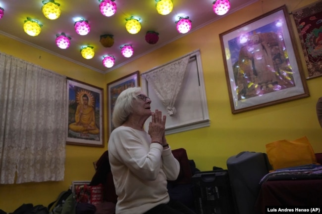 Carol Kruhen lifts up her pressed palms as she chanted sutras in Pāli language at the New Jersey Buddhist Vihara and Meditation Center in Franklin Township, N.J. on Sunday Nov. 30, 2024. (AP photo/Luis Andres Henao)