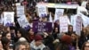 资料照片：人们在巴黎举着标语牌呼吁杜绝针对女性的暴力。(2019年3月8日)