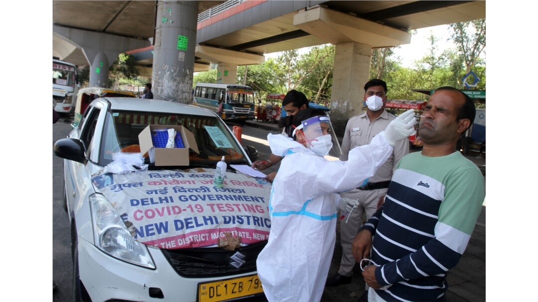 A man reacts as a health worker in protective suit takes his nasal swab sample to test for COVID-19 in New Delhi, India, May 22, 2021.