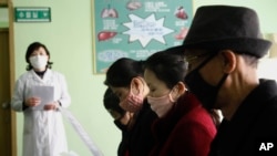 FILE - People review information explaining the COVID-19 coronavirus at the Phyongchon District People's Hospital in Pyongyang, North Korea, April, 1, 2020.