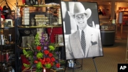 A large portrait of Larry Hagman and a bouquet of flowers are placed at the entrance of the gift shop at Southfork Ranch, where Hagman played the infamous J.R. Ewing for the TV series "Dallas," Parker, Texas, November 24, 2012. 