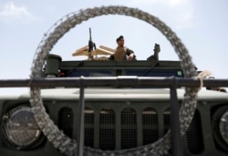An Afghan security forces member keeps watch as he sits in an army vehicle in Bagram U.S. air base, after American troops vacated it, in Parwan province, Afghanistan, July 5, 2021.