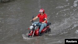 A motorcyclist drives on a flooded road after a heavy rainfall in Istanbul, Turkey July 18, 2017.