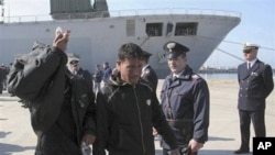 Migrants disembark from the Italian Navy vessel San Marco as they arrive at the harbour in Taranto , southern Italy, March 27, 2011