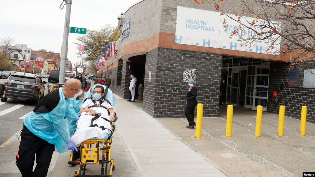 Emergency Medical Technicians move a patient while wearing personal protective equipment outside of Elmhurst Hospital during the ongoing outbreak of the coronavirus disease (COVID-19) in the Queens borough of New York, April 20, 2020.