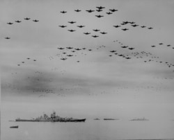 FILE - U.S. F4U and F6F planes fly in formation during surrender ceremonies aboard the USS Missouri, off Japan, Sept. 2, 1945. (U.S. National Archives/via Reuters)