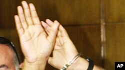 Jailed Palestinian leader Marwan Barghouti raises his handcuffed hands as he enters the courtroom for his murder trial in the Tel Aviv District Court, Israel (2002 file photo)