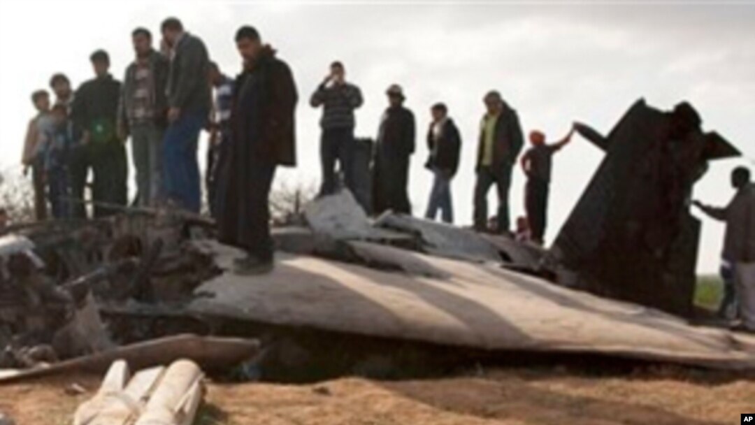 Libyans inspect the wreckage of a US F15 fighter jet after it crashed in an open field in the village of Bu Mariem, east of Benghazi, eastern Libya, March 22, 2011