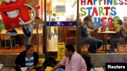 Anti-government protesters eat dinner outside a McDonald's restaurant in central Bangkok. Protesters occupy the same shopping and business districts, Feb. 6, 2014.