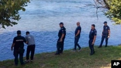 Serbian police officers search a bank of the Drina River near the town of Ljubovija, Serbia, on Aug. 22, 2024. (Serbian Ministry of Interior via AP)