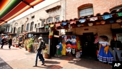 In this March 3, 2011 photo, tourists shop at Olvera Street stores at El Pueblo de Los Angeles Historic District in Los Angeles. (AP Photo/Damian Dovarganes)