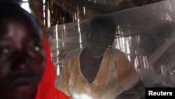 FILE - A Sudanese woman suffering from malaria sits inside her makeshift house in Golo, Fashoda county in Upper Nile State May 29, 2014.