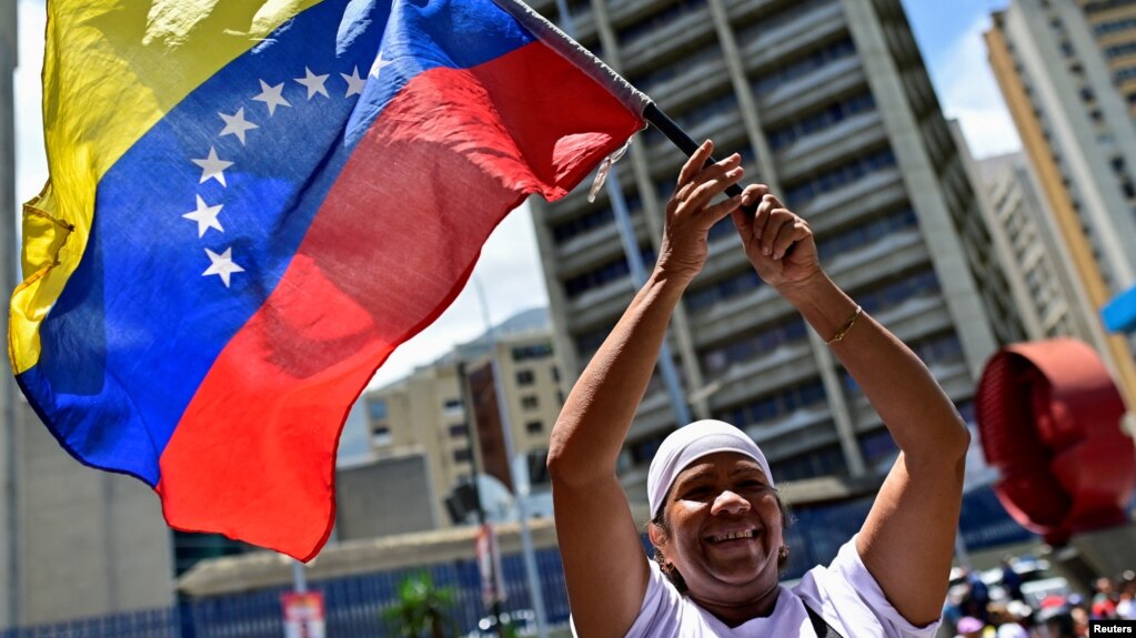 Una mujer simpatizante del presidente Nicolás Maduro ondea una bandera de Venezuela en un acto de cierre de campaña en Caracas.