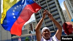 Una mujer simpatizante del presidente Nicolás Maduro ondea una bandera de Venezuela en un acto de cierre de campaña en Caracas.