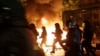 Police officers are silhouetted by fires lit by demonstrators during a protest against the G-20 summit in Hamburg, northern Germany, July 6, 2017.