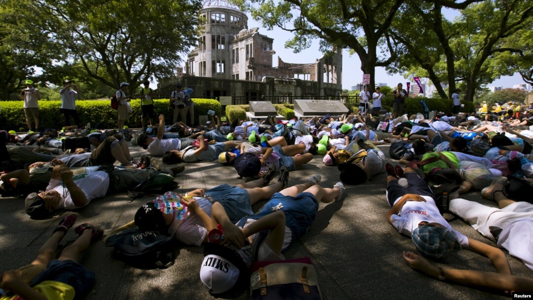 Anak-anak sekolah Jepang melakukan aksi teatrikal berpura-pura sebagai korban bom atom di depan 'Kubah Bom Atom' di kota Hiroshima, Rabu (5/8).