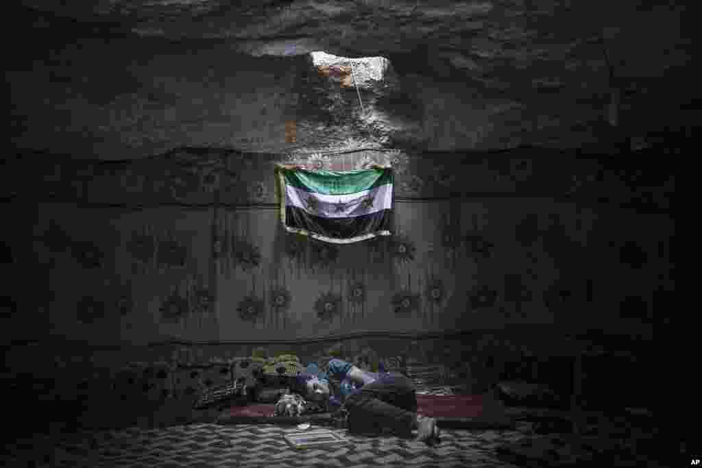 A Syrian opposition fighter rests inside a cave at a rebel camp in the Idlib province countryside, Sept. 17, 2013.