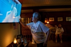 Karen Armstrong reaches to touch a screen displaying her grandson, U.S. swimmer Hunter Armstrong, during the 2020 Olympic Games in Tokyo, while his family watches from home in Dover, Ohio, July 25, 2021.