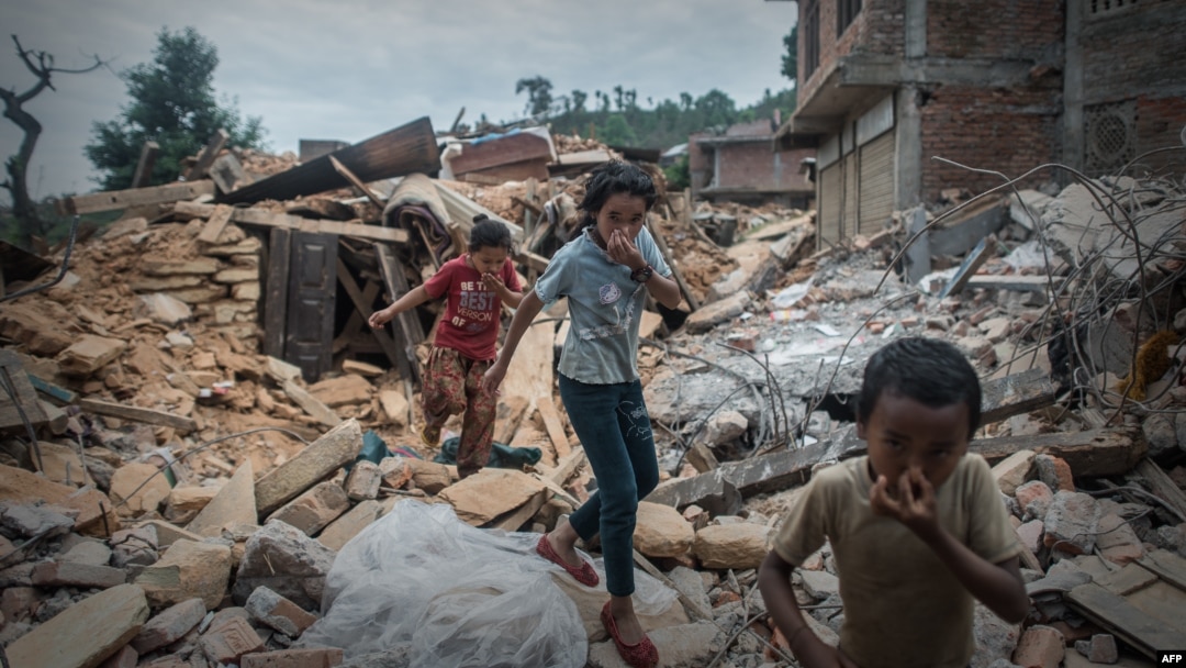 Anak-anak Nepal menutup hidung akibat bau jenazah korban gempa saat melewati puing-puing di Chautara, 80 kilometer dari ibukota Kathmandu (foto: dok). Nepal kembali diguncang gempa Selasa (12/5) sore. 