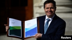 Ireland's Minister for Finance Paschal Donohoe displays a copy of the 2019 budget on the steps of Government Buildings in Dublin, Ireland, Oct. 9, 2018.