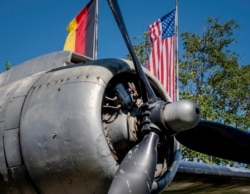 FILE - The propeller of a so-called "raisin bomber" airplane from World War II is seen in front of German and U.S. flags at the airport in Frankfurt, Germany, June 24, 2020.