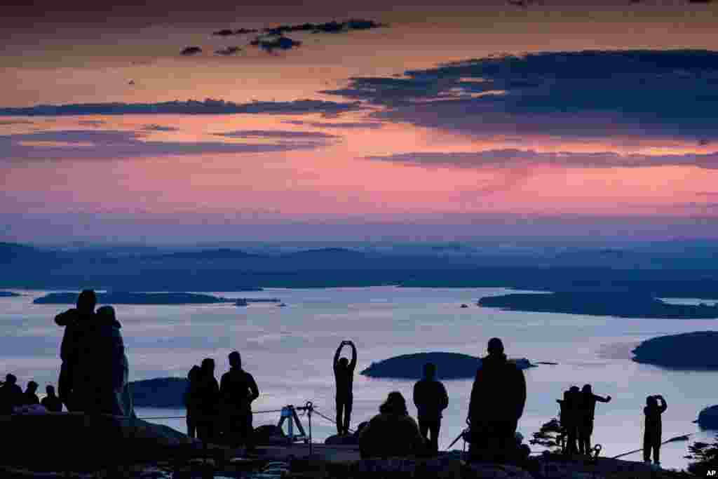 Early-rising visitors to Acadia National Park await the sunrise on the summit of Cadillac Mountain, near Bar Harbor, Maine.