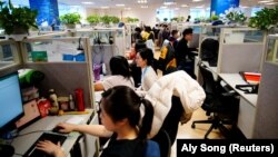 Karyawan bekerja di kantor perusahaan perjalanan online Ctrip.Com International Ltd di kantor pusatnya di Shanghai, selama tur media yang diselenggarakan pemerintah, setelah wabah COVID, China 14 Januari 2021. (Foto: REUTERS/Aly Song)