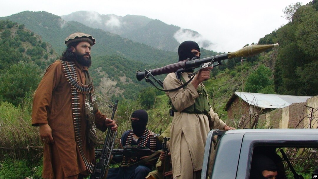 FILE - Pakistani Taliban patrol in their stronghold of Shawal in Pakistani tribal region of South Waziristan.