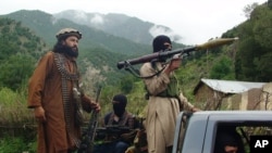 FILE - Pakistani Taliban patrol in their stronghold of Shawal in Pakistani tribal region of South Waziristan.