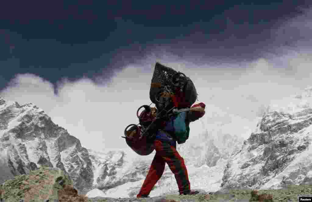 Seorang porter berjalan memikul beban dari kamp basis Everest di Nepal. (Foto: Dok)