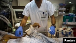 FILE - An Israeli nurse treats a wounded Syrian man, hospitalized for about two weeks, at Ziv Medical centre in Safed, northern Israel, Sept. 10, 2014. 