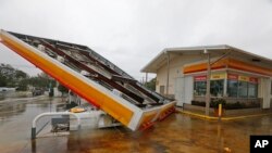 Atap dari sebuah pompa bensin tampak terlepas setelah diterbangkan oleh badai Irma di Miami utara, Florida, AS hari Minggu (10/9). 