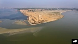 In this Tuesday, April 21, 2020, photo, deserted banks of the Sangam, the confluence of the rivers Ganges and Yamuna are seen during lockdown to control the spread of the coronavirus in Prayagraj, India. India’s extended lockdown to curb the…