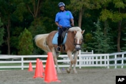 Dionne Williamson, of Patuxent River, Md., participates in a riding lesson at Cloverleaf Equine Center in Clifton, Va., Tuesday, Sept. 13, 2022. (AP Photo/Susan Walsh)