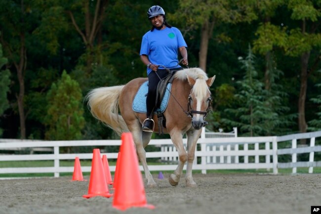 Dionne Williamson, of Patuxent River, Md., participates in a riding lesson at Cloverleaf Equine Center in Clifton, Va., Tuesday, Sept. 13, 2022. (AP Photo/Susan Walsh)