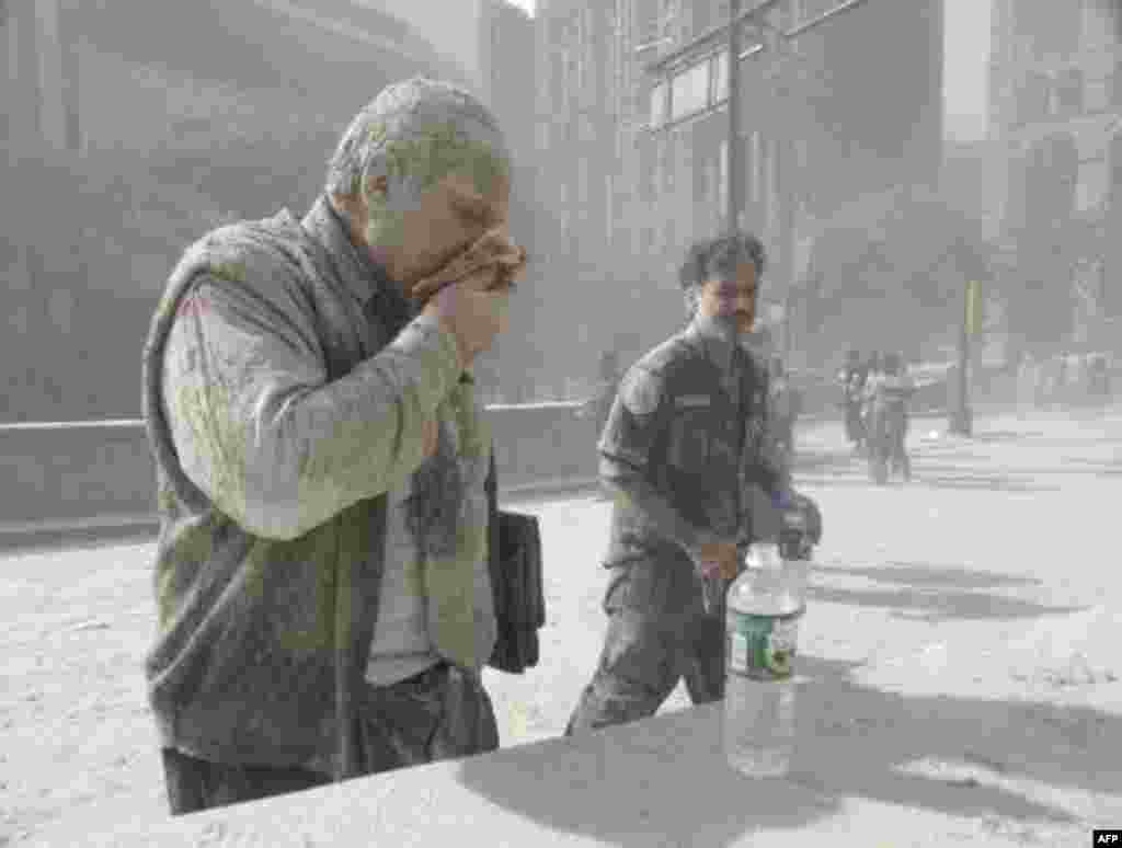 A man coated with ash and debris from the collapse of the World Trade Center south tower coughs near City Hall in lower Manhattan Sept. 11, 2001. (AP Photo/Amy Sancetta)