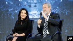 FILE - Rev. Jerry Falwell Jr., right, gestures as his wife, Becki, listens at a convocation at Liberty University in Lynchburg, Va., Nov. 28, 2018.