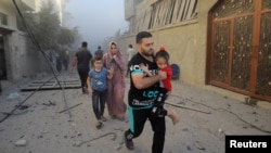 Los palestinos evacuan el lugar de los ataques israelíes contra las viviendas, en medio del conflicto en curso entre Israel y el grupo islamista palestino Hamás, en el campo de refugiados de Maghazi en el centro de la Franja de Gaza, el 6 de noviembre de 2023.