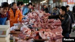 Meat stalls are seen at a market in Beijing, China, March 25, 2016. An exodus of small pig farmers in China is prolonging an industry downturn that will see the world's biggest pork producer and consumer challenge Japan as the top importer in 2016 for the first time.