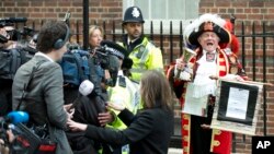 Tony Appleton, a town crier, announces to the assembled media the birth of the royal baby, outside the Lindo Wing, St. Mary's Hospital, London, Saturday, May 2, 2015.