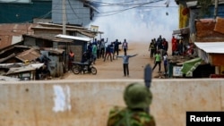 FILE - A riot police officer lobbs teargas canister to disperse supporters of Kenya's opposition leader Raila Odinga of the Azimio La Umoja in Nairobi, Kenya July 12, 2023.