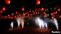 FILE - People watch fireworks to celebrate the start of the Chinese new year in front of a restaurant in Beijing, Jan. 31, 2014.