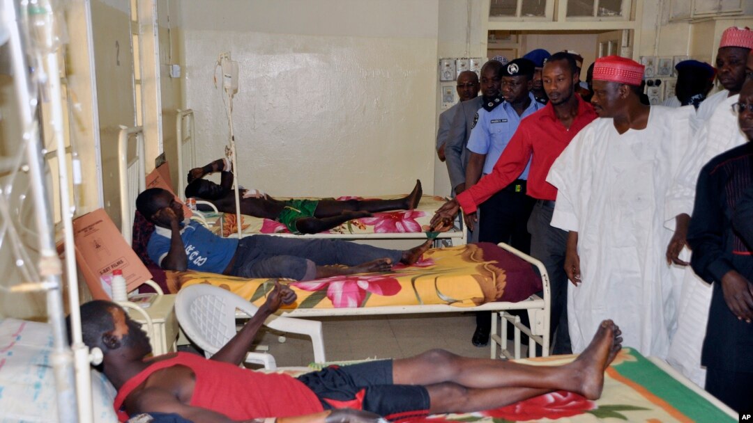 Pejabat pemerintah menengok warga yang terluka dalam ledakan bom bunuh diri di rumah sakit Kano, Nigeria (25/2). (AP/Sani Maikatanga)