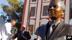 South African President Jacob Zuma (second l) talks with Mandla Mandela (l) after they and other dignitaries unveiled a bust of former South African President Nelson Mandela (r) at the South African Parliament in Cape Town, South Africa, April 28, 2014.