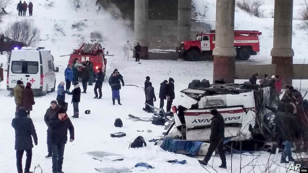 Para petugas menolong para korban luka-luka di lokasi jatuhnya bus di Sungai Kuenga, Siberia yang membeku hari Minggu (1/12). 