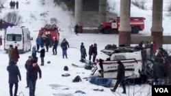 Para petugas menolong para korban luka-luka di lokasi jatuhnya bus di Sungai Kuenga, Siberia yang membeku hari Minggu (1/12). 