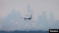 FILE - An Australian commercial aircraft prepares to land in the haze at Sydney's International Airport, July 15, 2014. 
