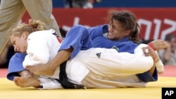 Sarah Menezes, de Brasil (en azul) aplica una llave a la rumana Alina Dumitru, durante la ronda final de la competición de judo en 48 kgs, que ganó finalmente la brasileña.