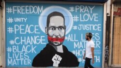 A man walks past a mural depicting George Floyd during a protest over the death of Floyd Sunday, May 31, 2020, in Los Angeles. Floyd died in Minneapolis on May 25 after he was pinned at the neck by a police officer. . (AP Photo/Ringo H.W. Chiu)